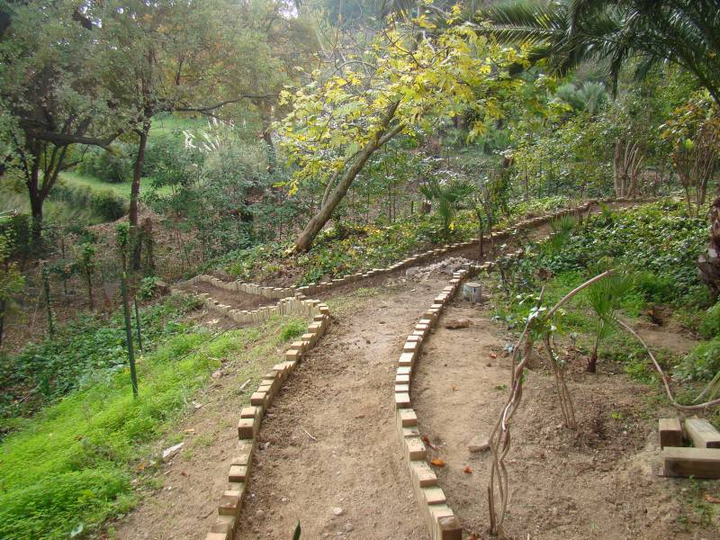 Chemin aménagé avec gravier coloré et bordures en bois dans un jardin de 1200 m² à Antibes.